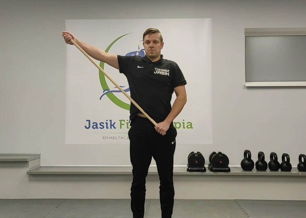 Mężczyzna wykonuje ćwiczenie ze sztangą.