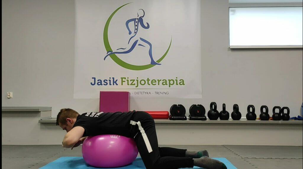 Fizjoterapia, mężczyzna na piłce rehabilitacyjnej