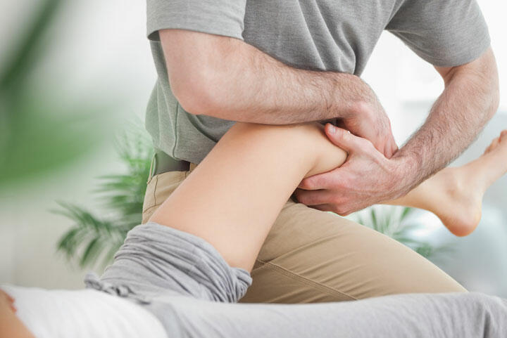Fizjoterapeuta pracuje z kolanem i udem pacjentki